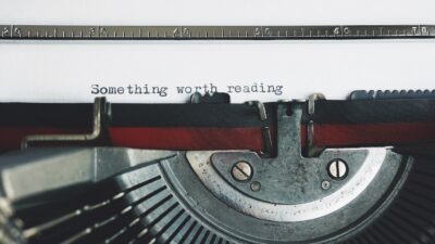 Máquina de escribir con una hoja que dice 'Something worth reading'